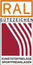 Rechteckiges Logo mit rot-weiß gestreiftem Hintergrund und schwarzem Text: RAL GÜTEZEICHEN sowie darunter KUNSTSTOFFBELÄGE SPORTFREIANLAGEN (KI-generiert)